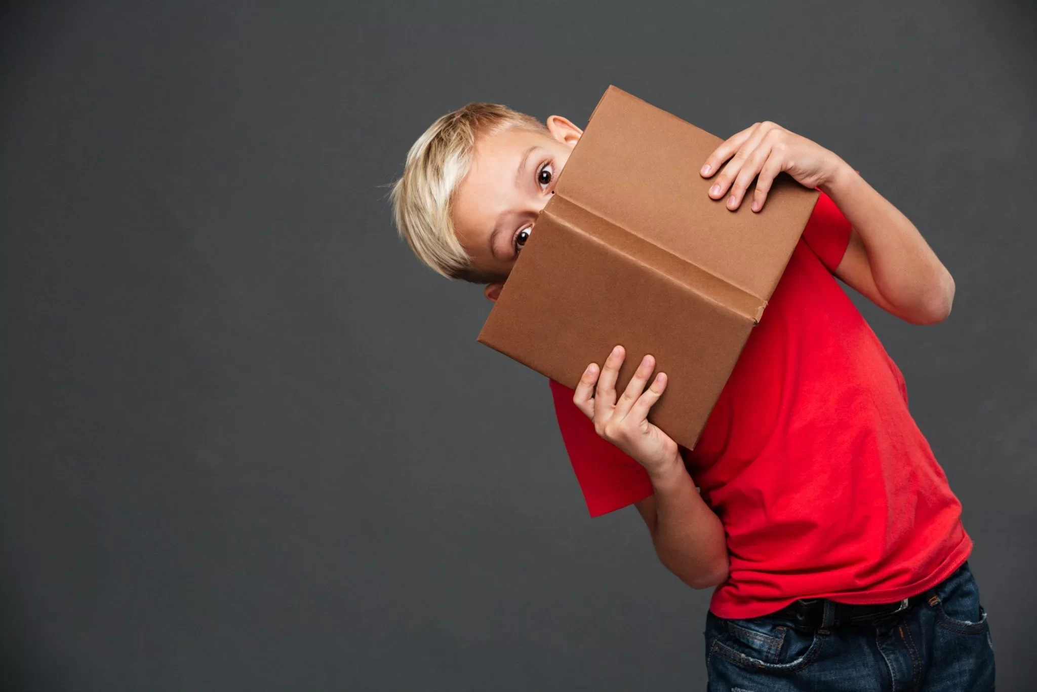 little boy child covering face with book scaled