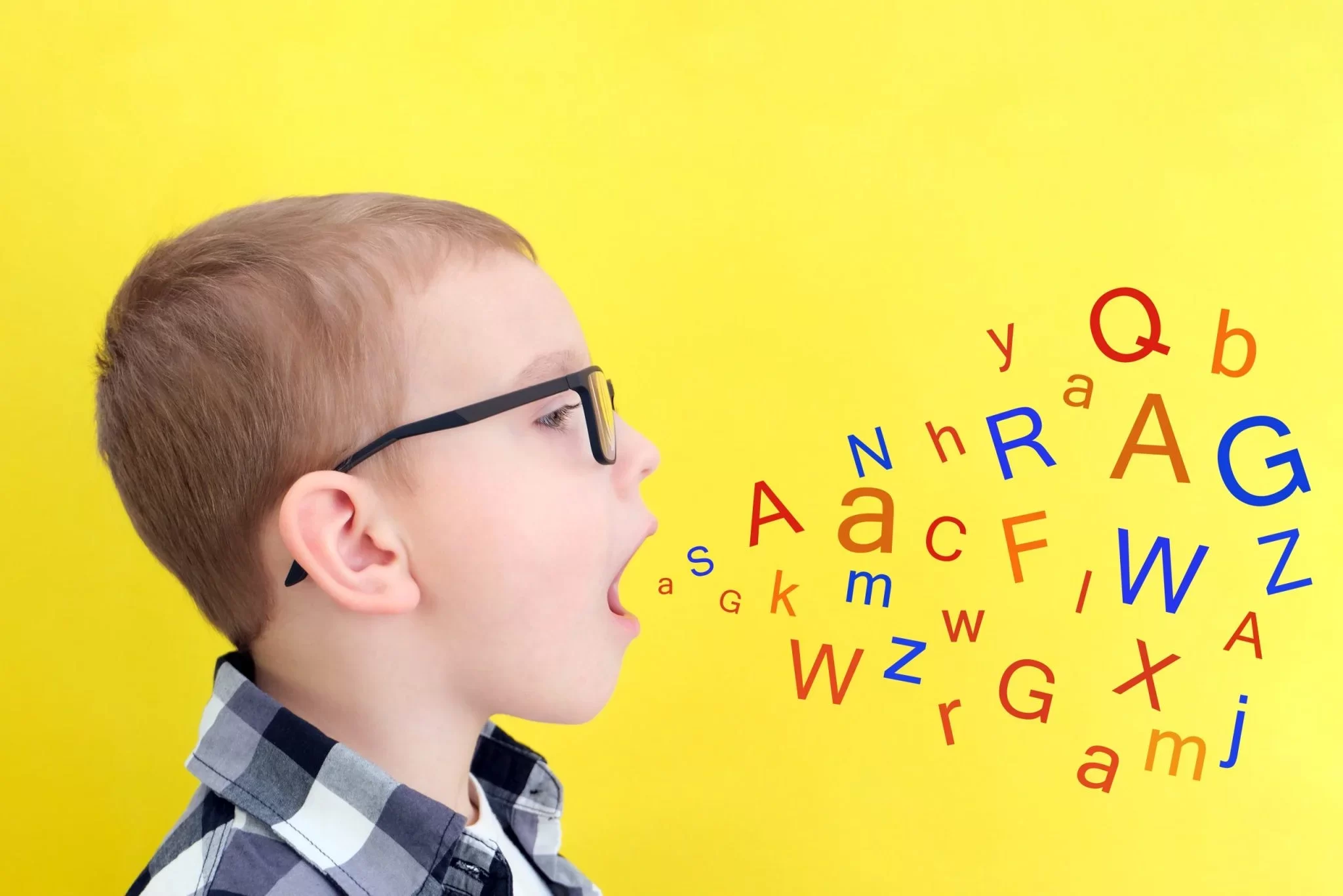 speech therapy toddler boy says open mouth with letters classes with speech therapist boy isolated yellow background scaled